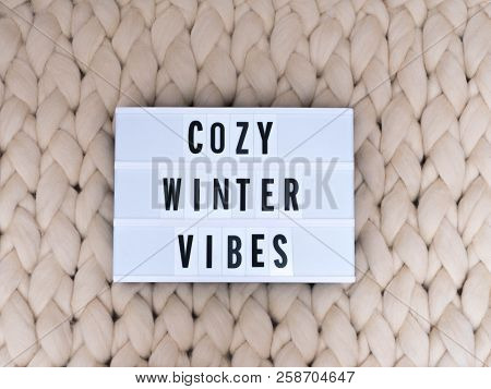 Cozy Winter Vibes Word On Lightbox On Knit Background. Cozy Compozition. Knit Background.