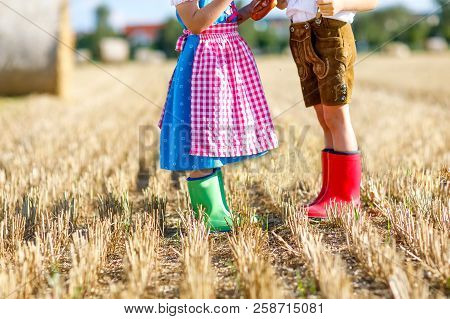 Two Kids In Traditional Bavarian Costumes And Red And Green Rubb