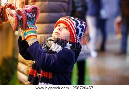 Little Cute Kid Boy Buying Sweets From A Cancy Stand On Christmas Market