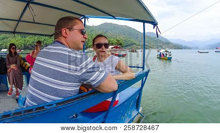 Pokhara, Nepal - April 10, 2018: The People Sitting At Colorful Wooden Boat At Fewa Lake In Pokhara,