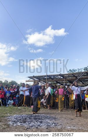 Bajawa, Indonesia - May 19: Unidentified Men Dance In Front Of A The Ashes Of A Ceremonial Fire Near