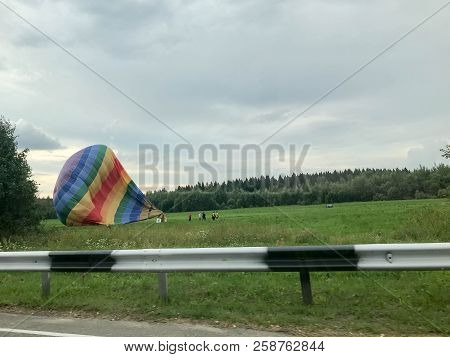 Blowed Down Deflate A Large, Colorful, Colorful, Round, Rainbow Colored, Striped, Flying Balloon. Th
