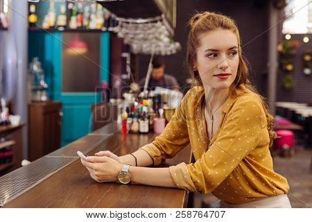 Calm Woman Sitting At The Bar Counter And Turning Her Head
