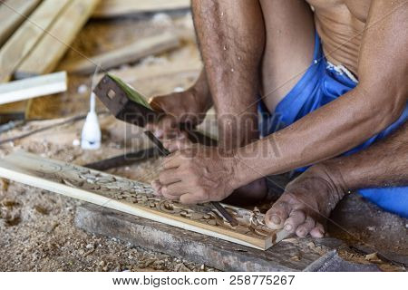 Isolated Hands Chiseling On The Ground Of A Wood Working Shop In Nuda Penida, Indonesia.