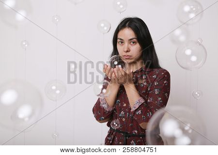 Beautiful Girl Among The Glass Balls One Of Which She Holds In Her Hands