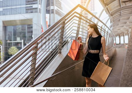 Young Cheerful Lady Smling And Holding Shopping Bags In Mall,happy Female Walking Out From Departmen