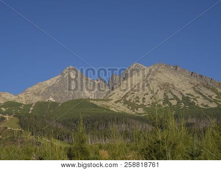 Tatra Mountains Range Gold Colored Sunrise Light , From Tatranska Lomnice With Green Trees And Grass