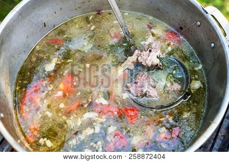 Top View Of Cooking Central Asian Shurpa (soup From Meat And Large-sliced Vegetables) In Pot Outdoor