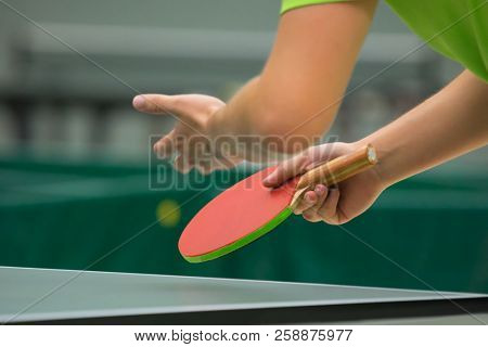 Table tennis player serving, close up