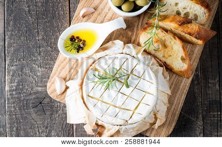 Baked Camembert Cheese. Fresh Brie Cheese And A Slice On A Wooden Board With Nuts, Honey, Rosemary, 