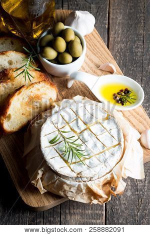 Baked Camembert Cheese. Fresh Brie Cheese And A Slice On A Wooden Board With Nuts, Honey, Rosemary, 