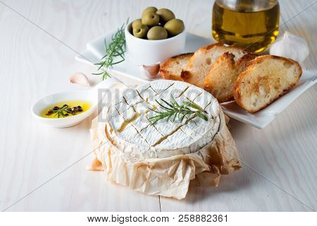 Baked Camembert Cheese. Fresh Brie Cheese And A Slice On A Wooden Board With Nuts, Honey, Rosemary, 