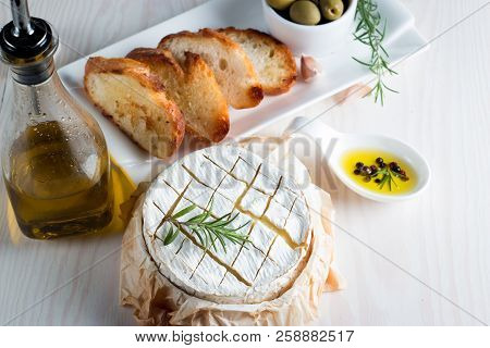 Baked Camembert Cheese. Fresh Brie Cheese And A Slice On A Wooden Board With Nuts, Honey, Rosemary, 