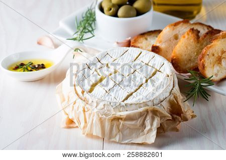 Baked Camembert Cheese. Fresh Brie Cheese And A Slice On A Wooden Board With Nuts, Honey, Rosemary, 