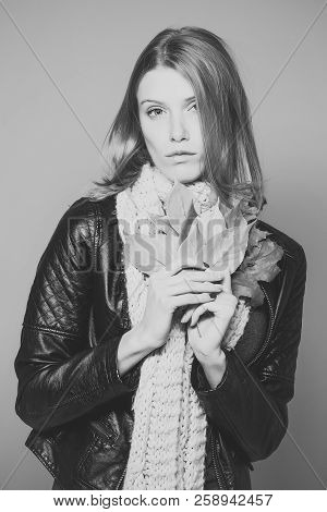 Woman With Autumn Leaves In Leather Jacket And Scarf On Orange Background