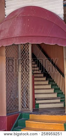 Doorway And Stairs Covered By An Old Red Canvas Canopy In A Dilapidated Building