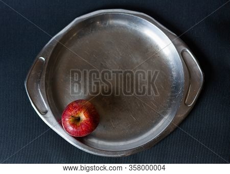 Red Apple On Old Steel Plate And Black Background. Top View. Chiaroscuro. Snow White Apple