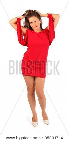 Belle femme habillée en robe rouge danses en studio sur fond blanc.