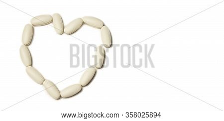 Tablets. Pills Background. White Pills On A White Background. The Pills Are Laid Out By The Heart. I