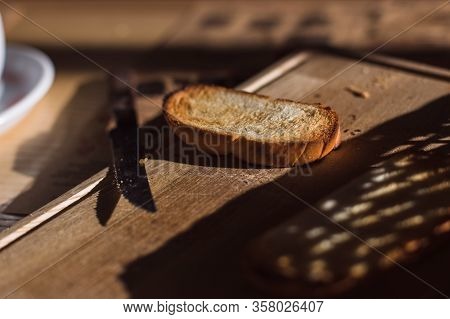 Piece Of Bread And Knife On The Wooden Table