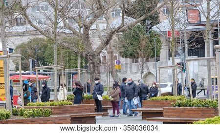 Istanbul, Turkey - 25 March, 2020: A Crowded Line Of People In Protective Face Masks Are In The Queu