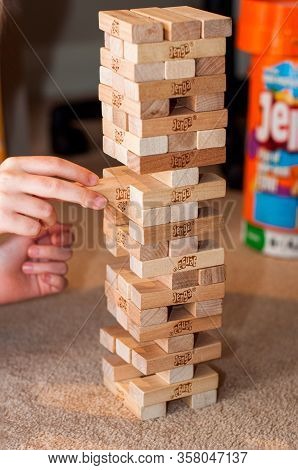 Stay Home Coronavirus Concept. Hands Playing Wooden Block Jenga Game