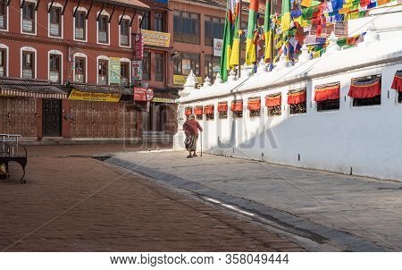March 25, 2020. Kathmandu, Nepal. The ​​stupa Bouda Closed On Quarantin. A Lonely Grandmother Makes 