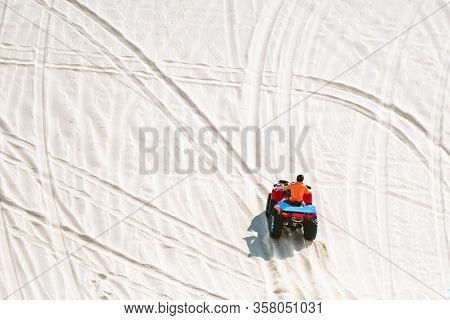 Tourist Enjoy Riding The Quad Bike Or Powerful Fast Off-road Four-wheel Drive Atvs At White Sand Dun