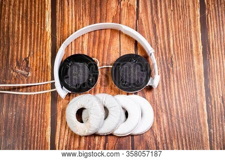 Need A Replacement Embouchures On Old White Earbud. Repair Accessories.wooden Background