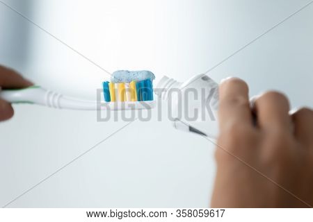 Close Up Image Female Hands Squeezes Toothpaste On Toothbrush
