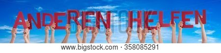 People Hands Holding Word Anderen Helfen Means Help Others, Blue Sky