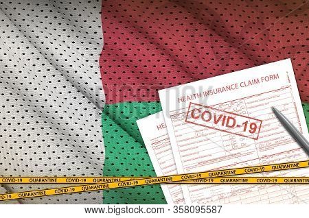 Madagascar Flag And Health Insurance Claim Form With Covid-19 Stamp. Coronavirus Or 2019-ncov Virus 