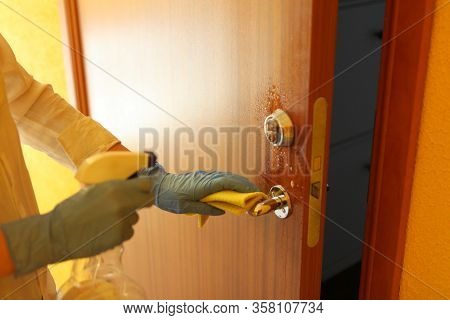Cleaning Door With Sanitarizer - Womans Hand In Blue Medical Protective Glove With Rag Wiping Doors 