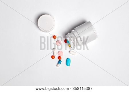 White Plastic Bottle With Medicines And Vitamines. Tematic Health. Rose, Orange And Blue Medicines.