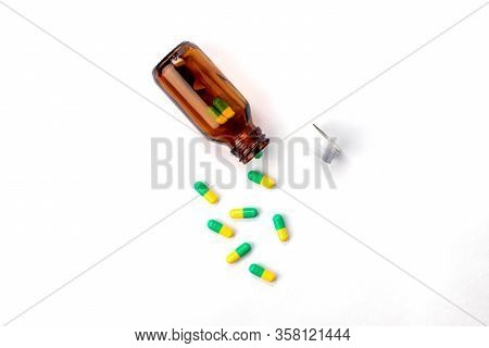 Glass Bottle With Medicines And Vitamins Inside. Green And Yellow Pills. Cap Bottle And Health Temat