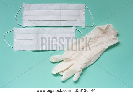 White Latex Gloves And Medicinal Facial Mask On Aquamarine Background. Space For Text.