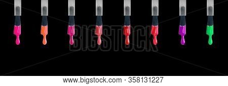 Nail polish. Colorful various nailpolish drops on brush, isolated on black background. Fashion beautiful nail art, Design of female colourful nailart, Dripping colored UV nail varnish