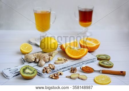 Food To Boost Immunity. Citruses, Ginger, Turmeric, Kiwi, Walnuts On A Light Wooden Table. Close-up