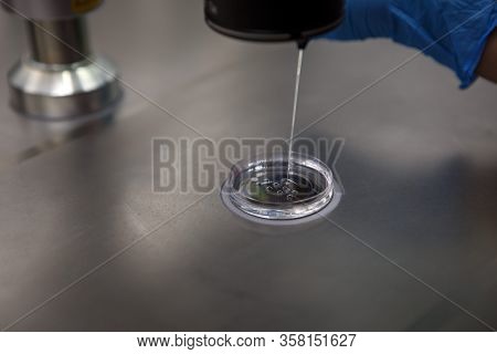 The process of artificial insemination in IVF clinic. Hands doctor in blue rubber gloves produce che