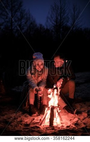 Winter Picnic On Baech With Bonfire. Love Story On Winter Foggy Sand Beach. Fry Marshmallows At The 