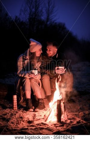 Winter Picnic On Baech With Bonfire. Love Story On Winter Foggy Sand Beach. Drink Hot Tea In Cold We
