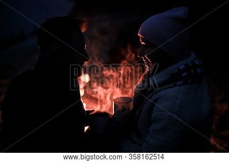 Winter Picnic On Baech With Bonfire. Love Story On Winter Foggy Sand Beach. Drink Hot Tea In Cold We