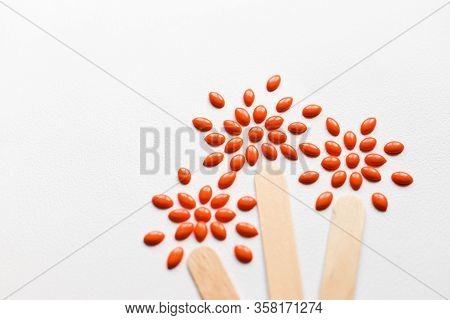 Orange Waxing With Wooden Sticks On The White Background