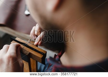 Man Hands Quilting The Leather With Filament On The Special Wooden Instrument
