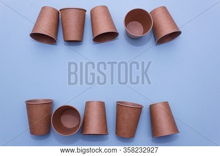 Many craft paper cups for coffee or any drinks on a  blue paper background. Concept of ziro waste, n