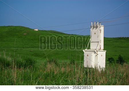 Small Booth With Electrical Distribution Box In A Field Of Green Grass.