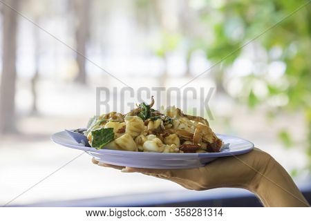 Stir Fried Basil Leaf Shrimp And Squid With Rice On The Plate In Hand.
