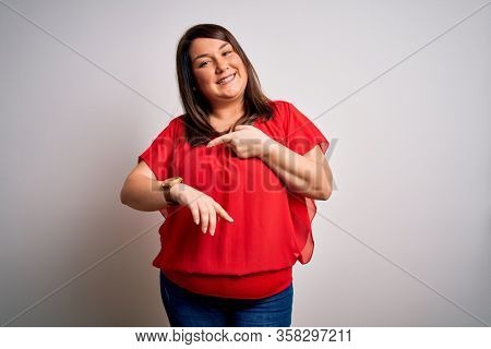Beautiful brunette plus size woman wearing casual red t-shirt over isolated white background In hurry pointing to watch time, impatience, upset and angry for deadline delay