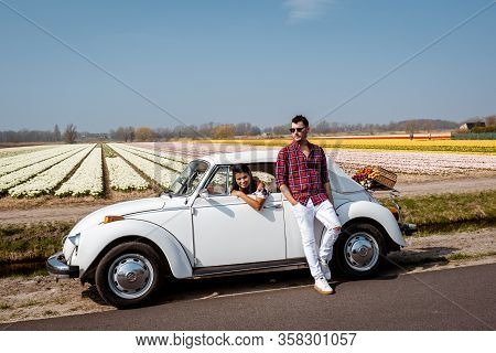 Lisse Netherlands April 2019, A Classic, White Volkswagen Beetle Car On A Flower Covered Meadow In T