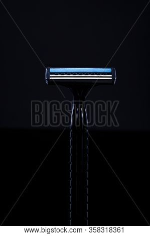 Disposable Shaving Machine. Black Razor On A Black Background. Black Razor With A Blue Line.